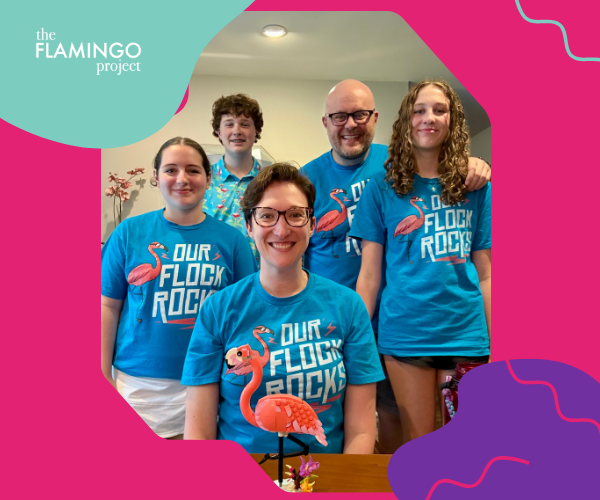 Tech-Culture-03 A smiling group of five people wearing bright blue “Our Flock Rocks” flamingo T-shirts, posed indoors with a LEGO flamingo on the table. The Flamingo Project branding frames the image with pink, teal, and purple design elements.