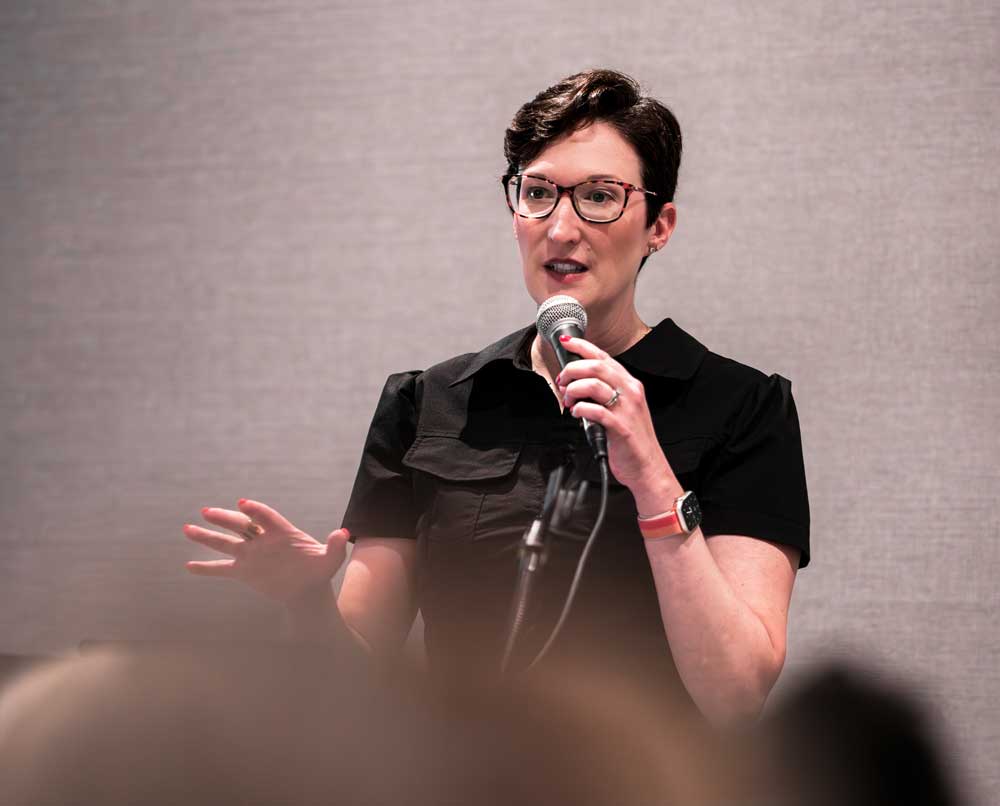 Sarah Kinard presenting on stage at an A/E/C professional event, engaging the audience.